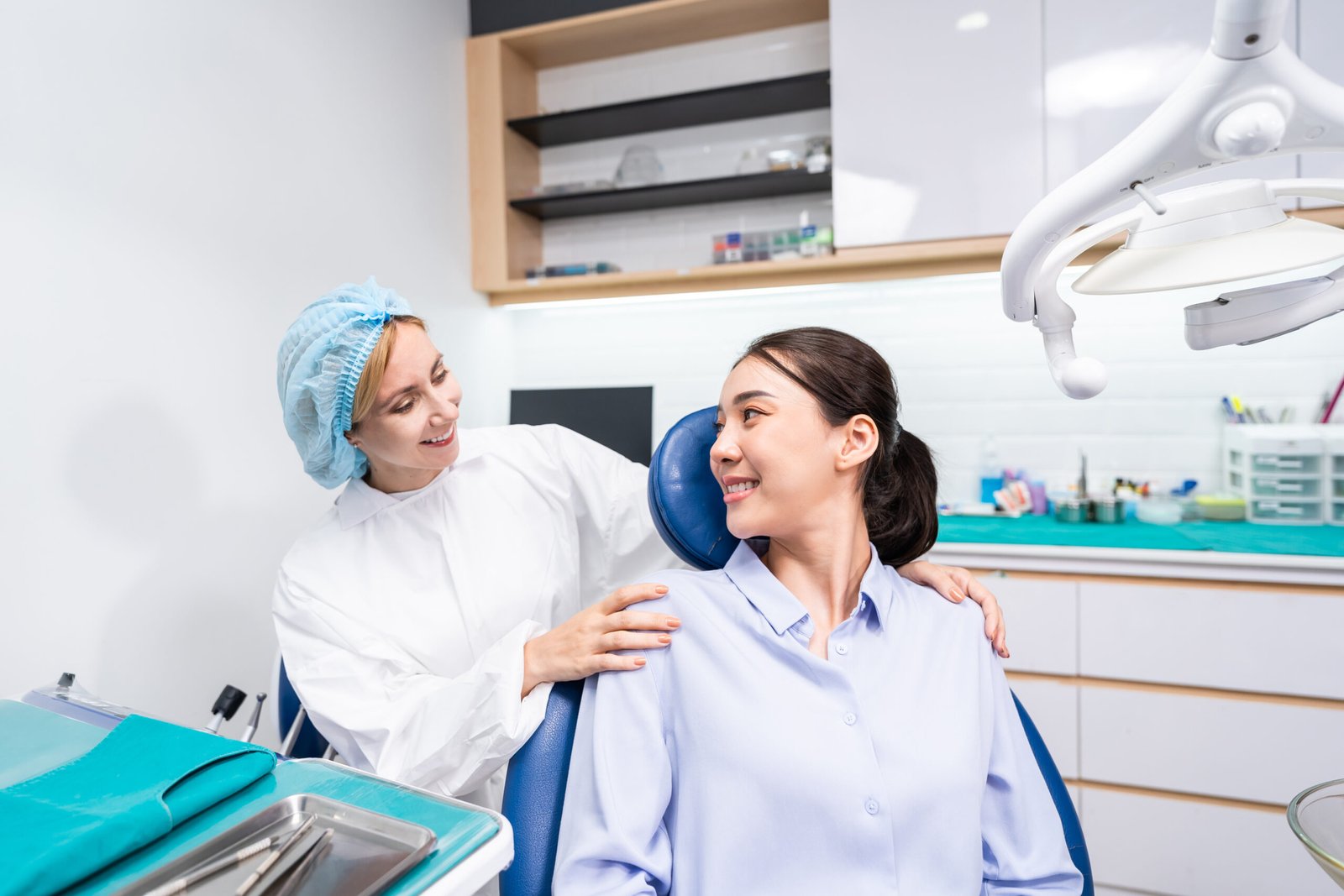 Caucasian dentist examine tooth for young girl at dental health clinic. Attractive woman patient lying on dental chair get dental treatment from doctor during procedure appointment service in hospital