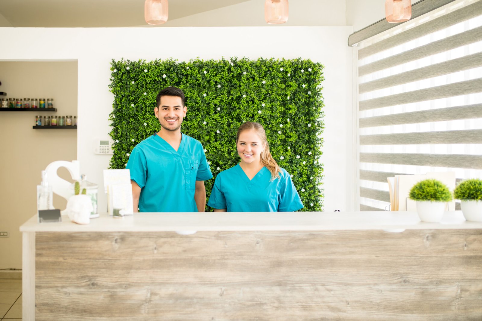 Portrait of confident physiotherapists standing at reception counter in hospital